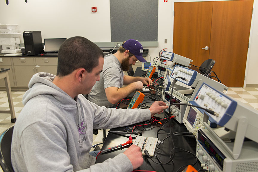 electrical engineering students working on equipment