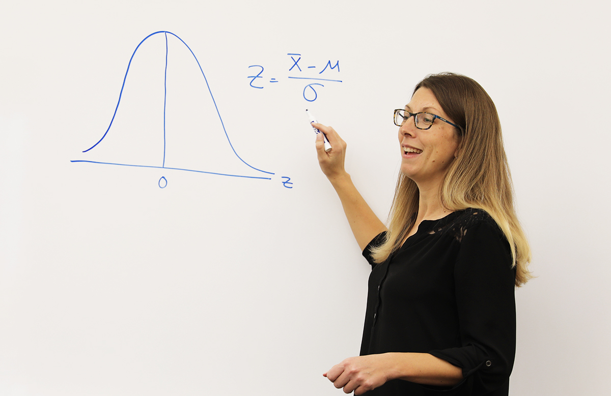 professor pointing at equation on whiteboard