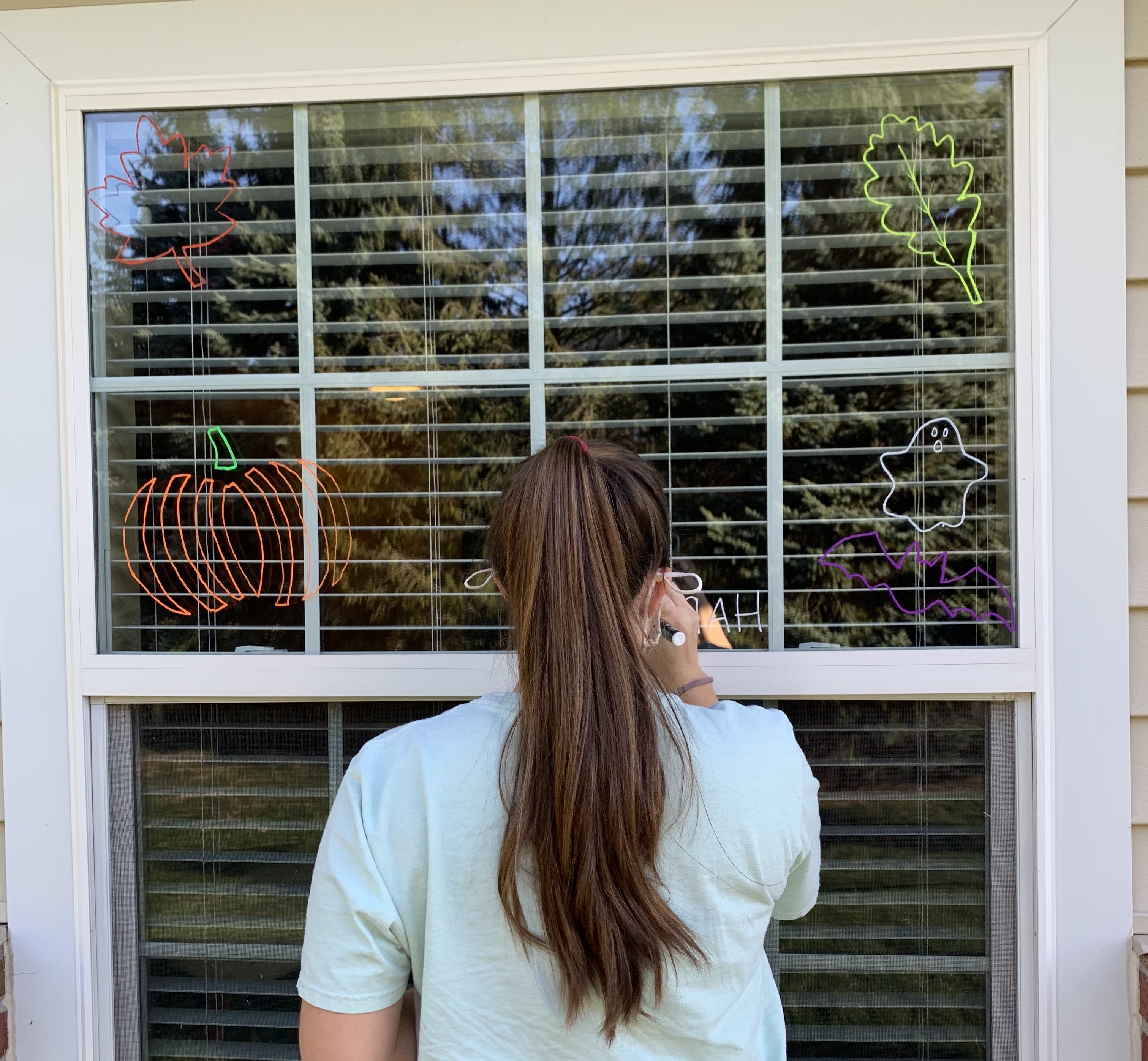 student painting on window