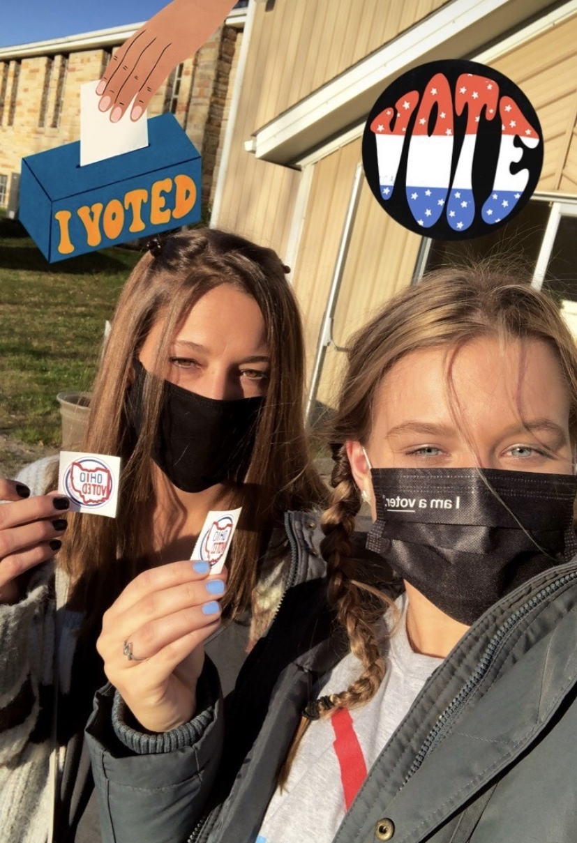 two students holding up voting stickers