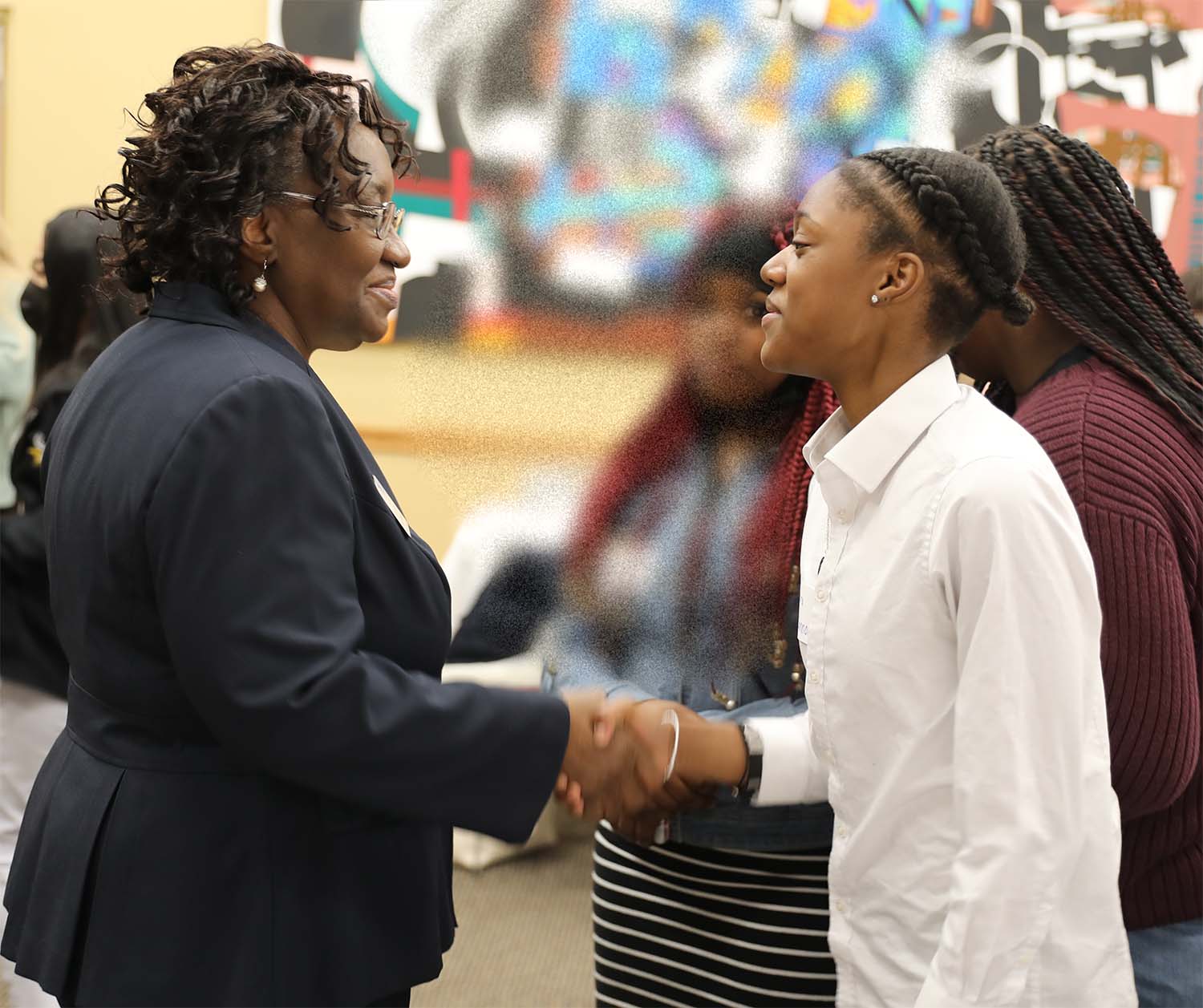 christ baker shaking hands with student