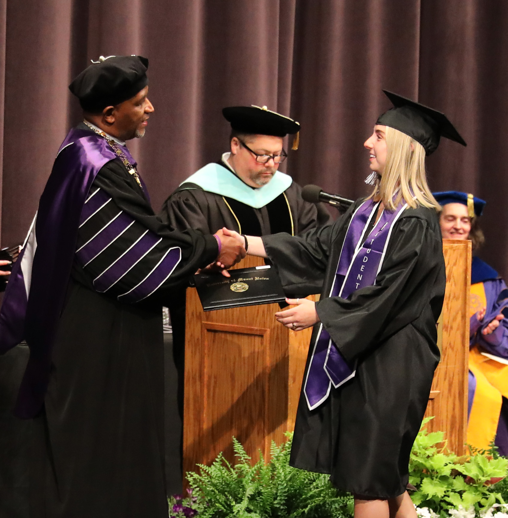 graduate shaking hands with president greg king