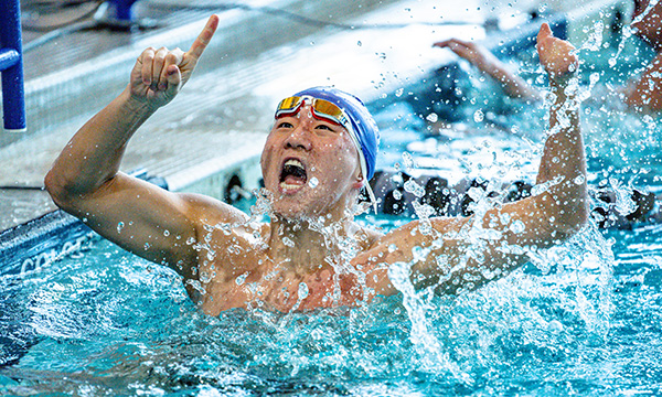 A member of the men's swimming and diving team celebrating a victory in the pool