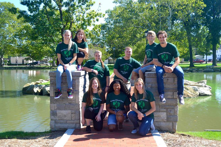Green Raiders pose for a picture on the bridge at Campus Lakes