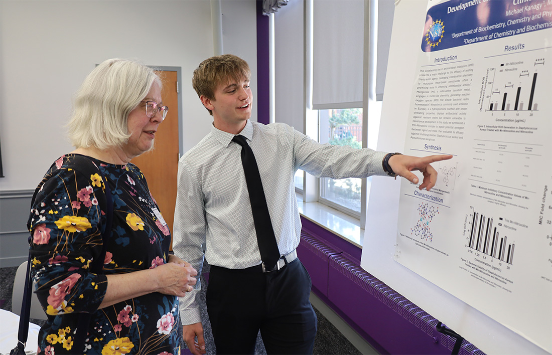 chemistry student presenting research to community member