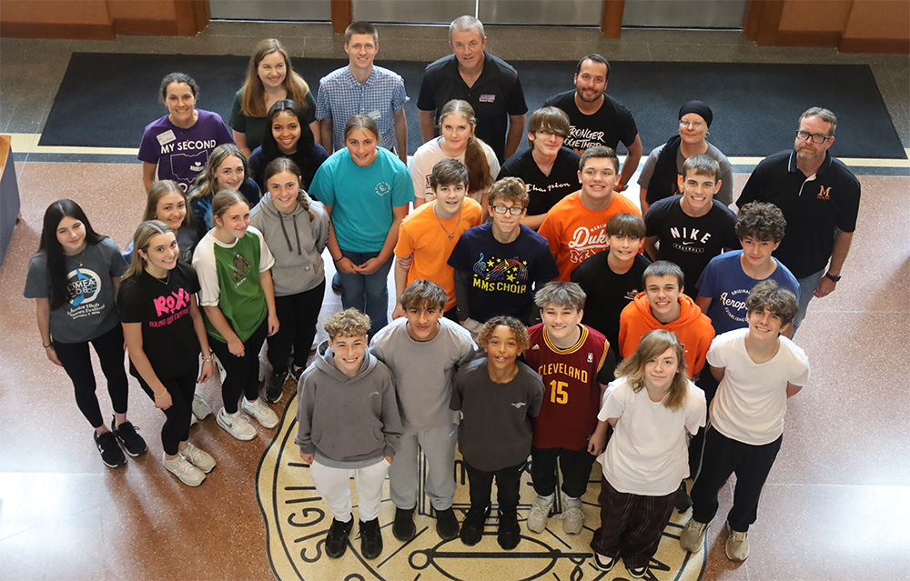 group of middle school students posing with faculty