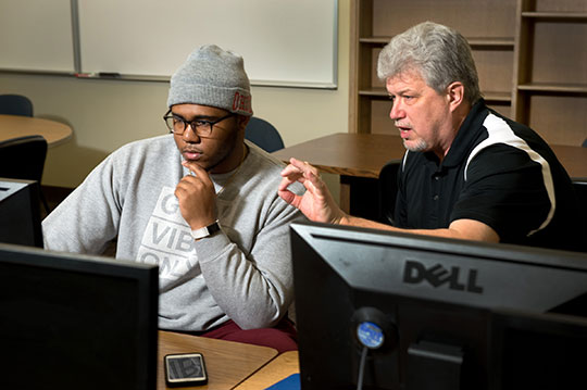 Blase Cindric with a student on a computer 