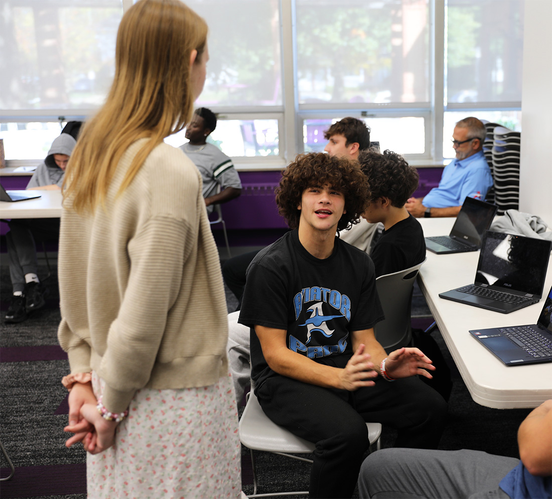 Student talking to an individual standing