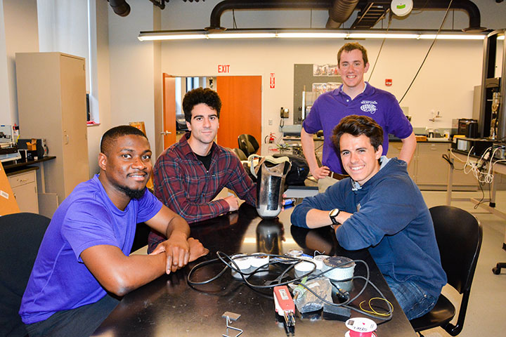 Adaptable prosthetic leg team posing around their project