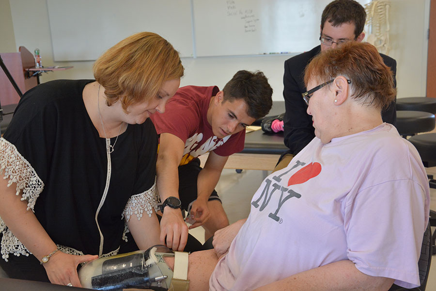 Engineering students and PT faculty member testing an adaptable prosthetic leg