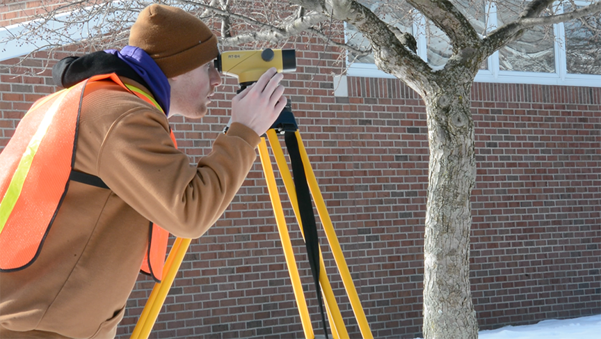 Civil engineering student using surveying equipment
