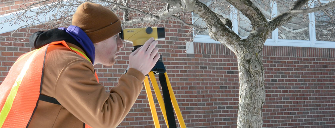 Civil engineering student using surveying equipment