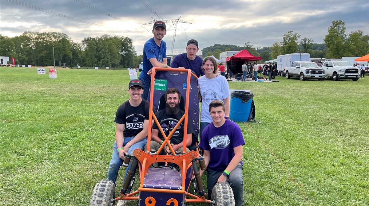 students sitting on baja car