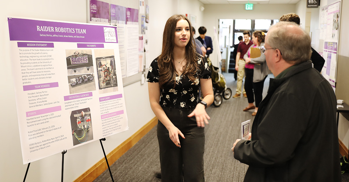 female student presenting research to community member