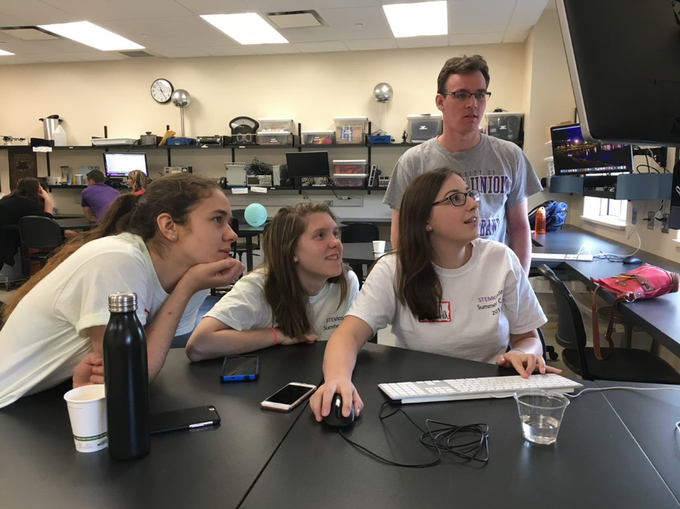 students looking at computer at lab table