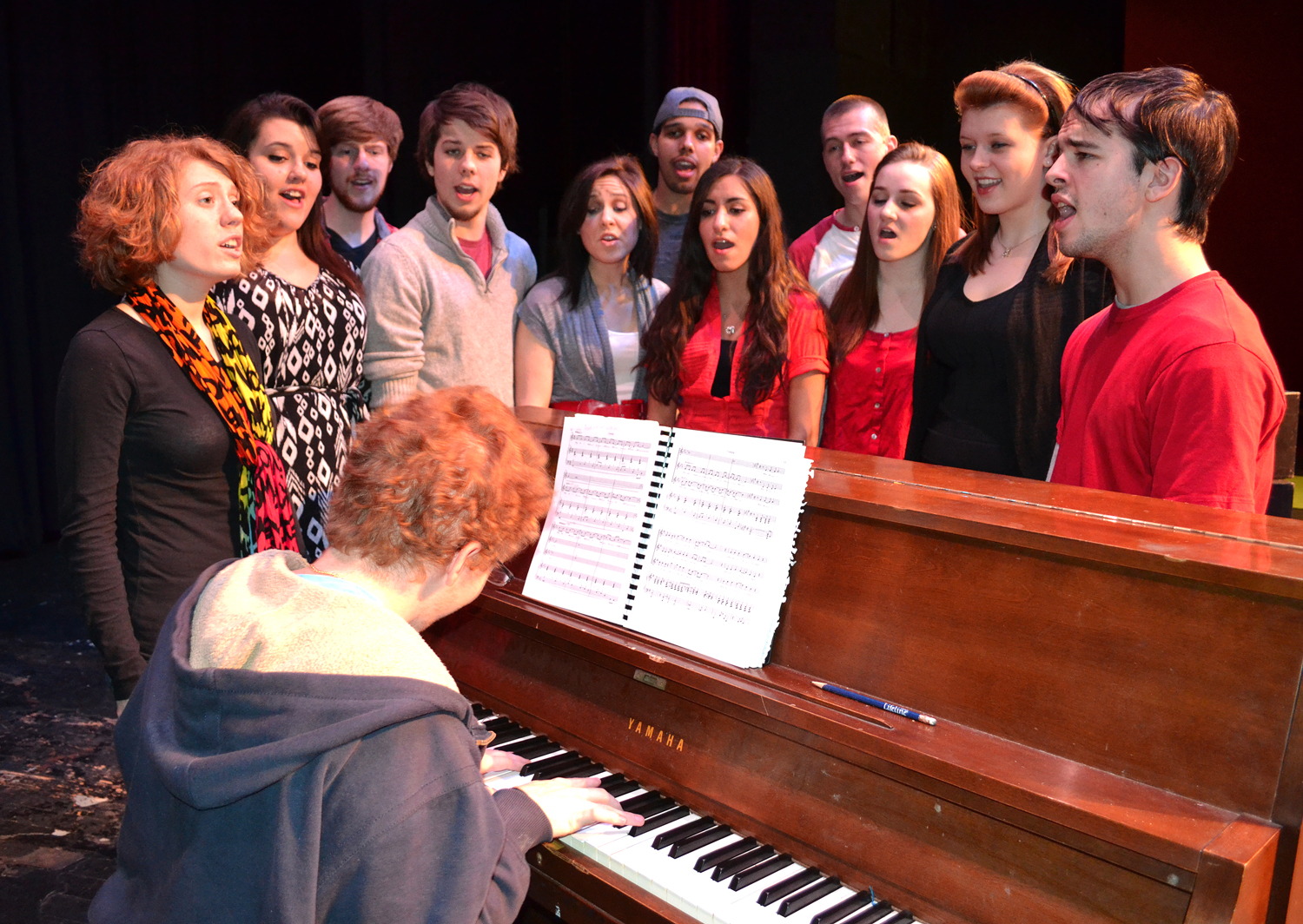 Cast singing by piano 
