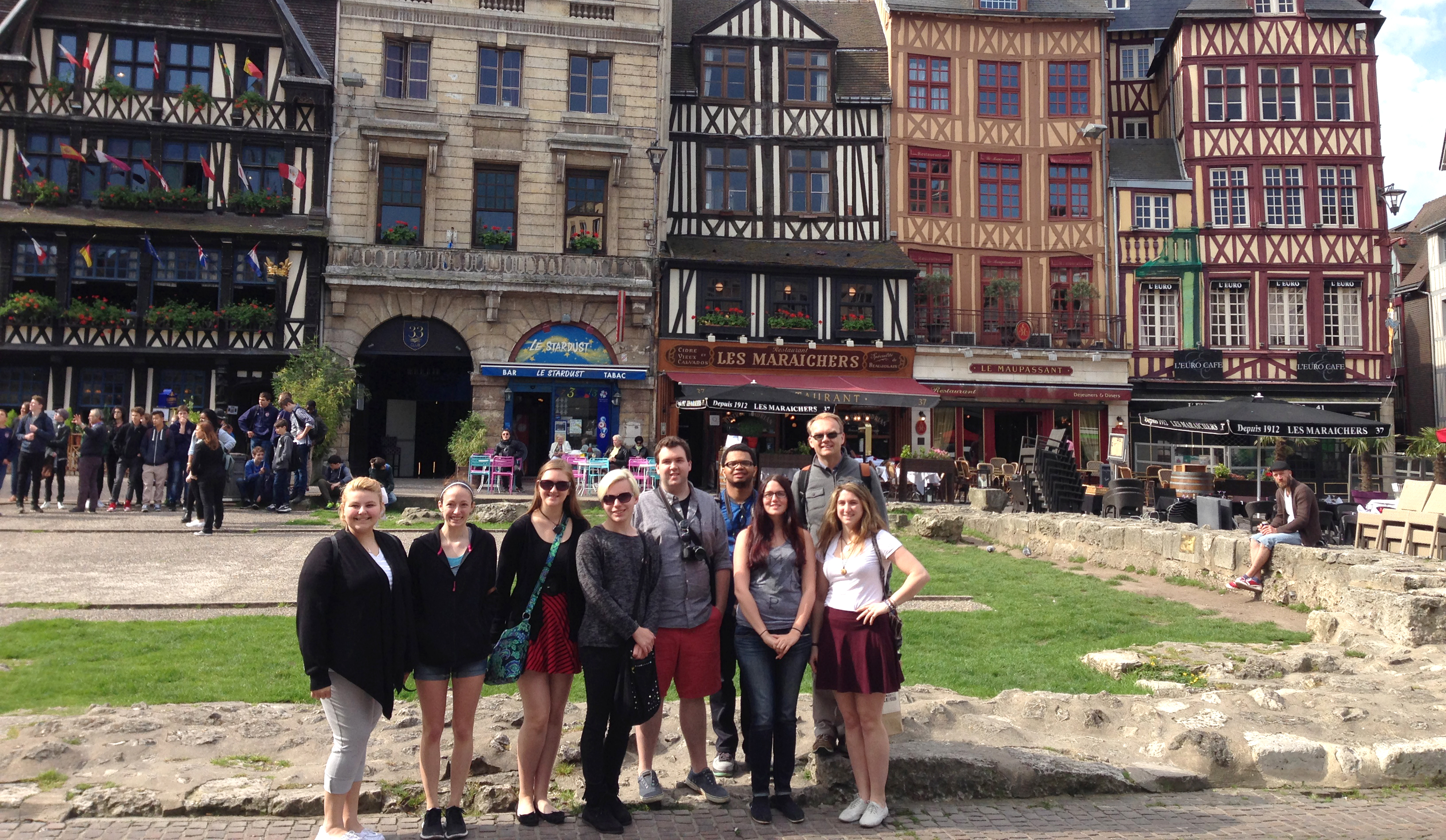 Professor with a group of students gathered in a French city