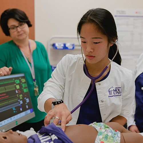 student using stethescope on dummy