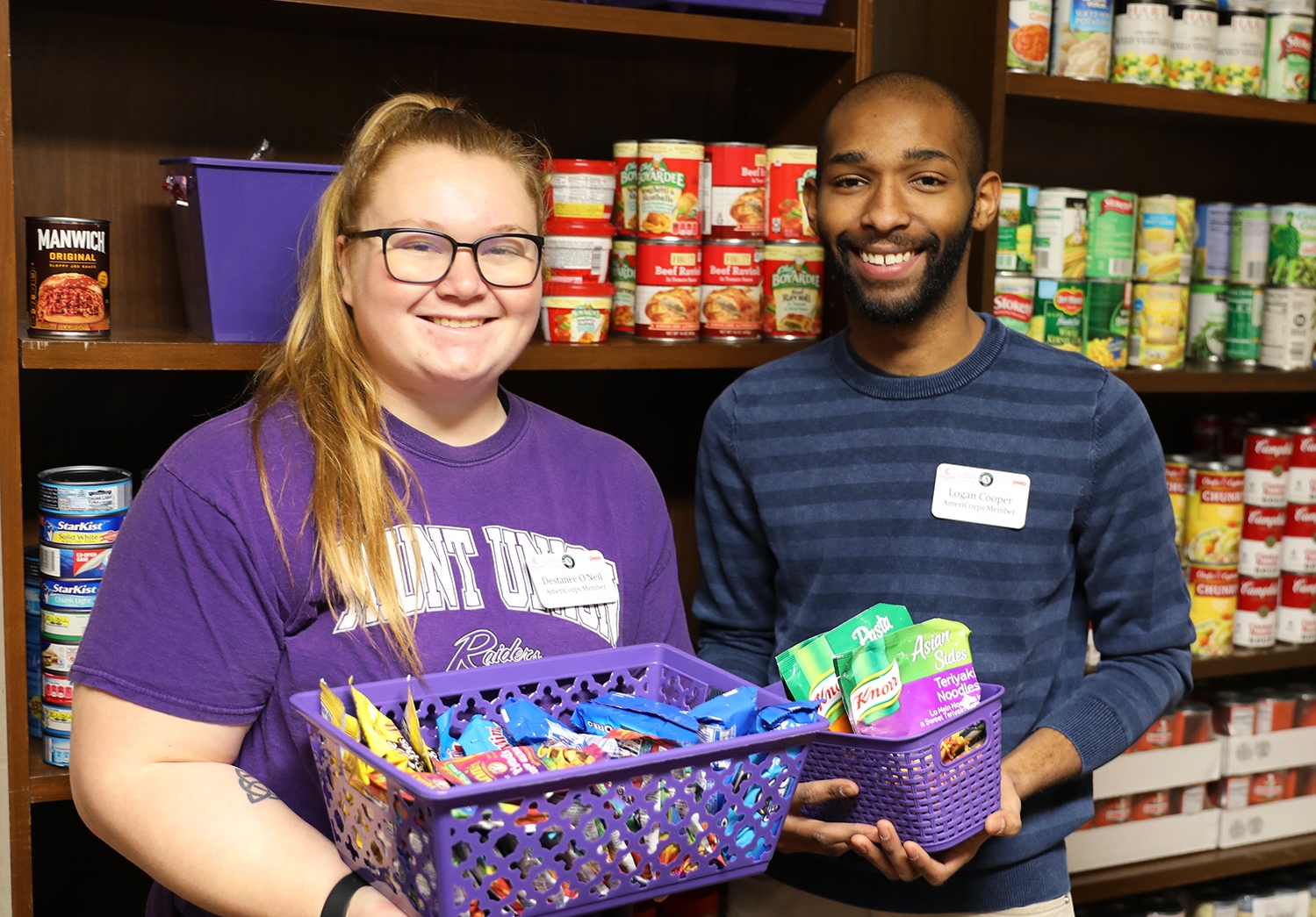 Students holding canned goods in Raiders Cove