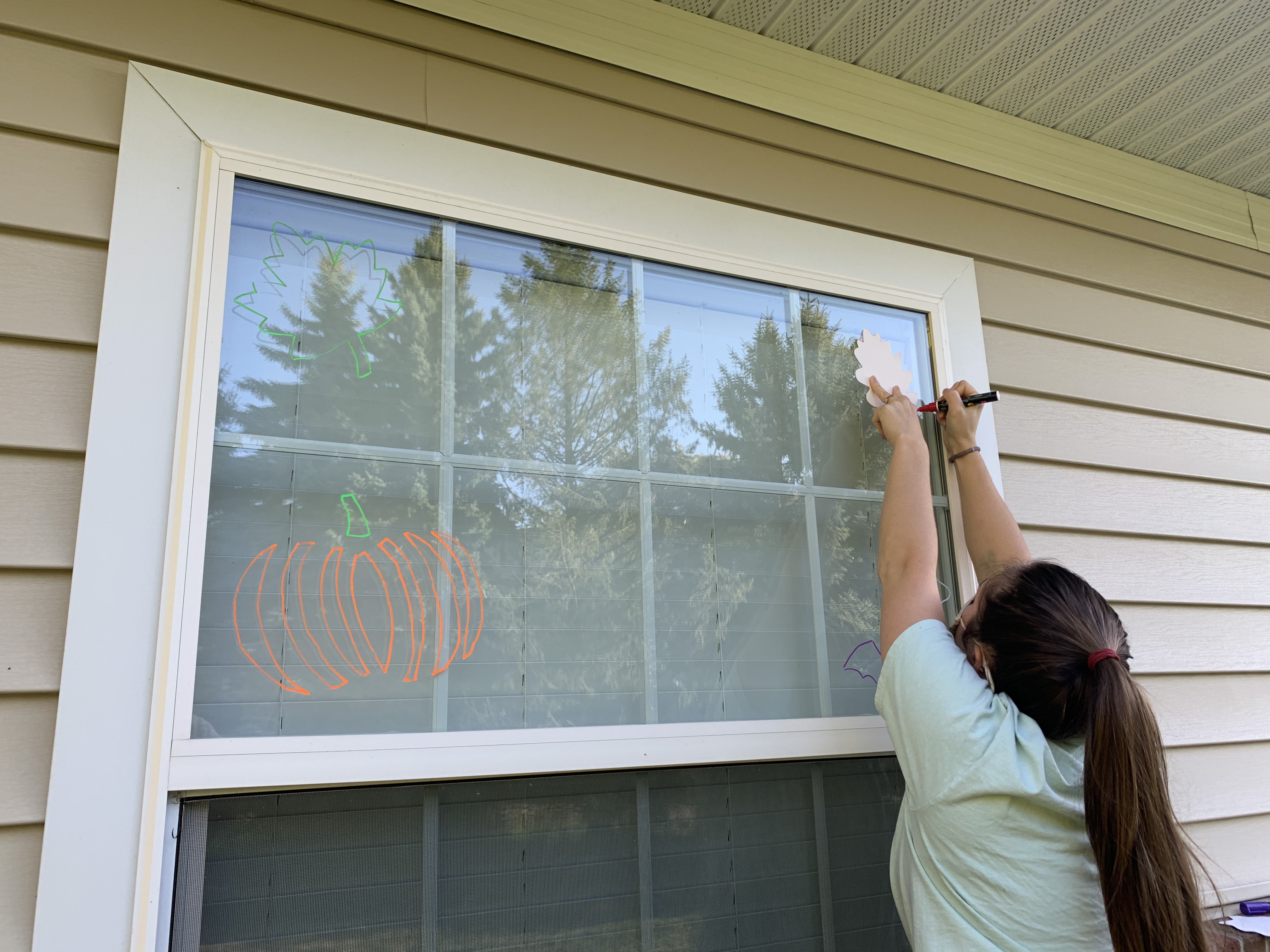 student painting on window