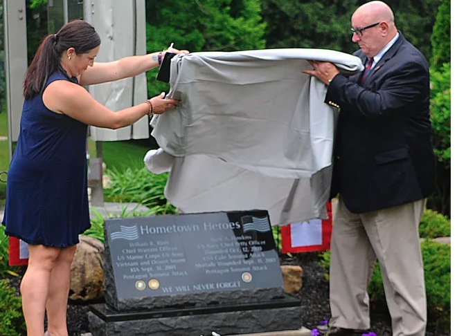 woman on left and man on right unveil tribute marker