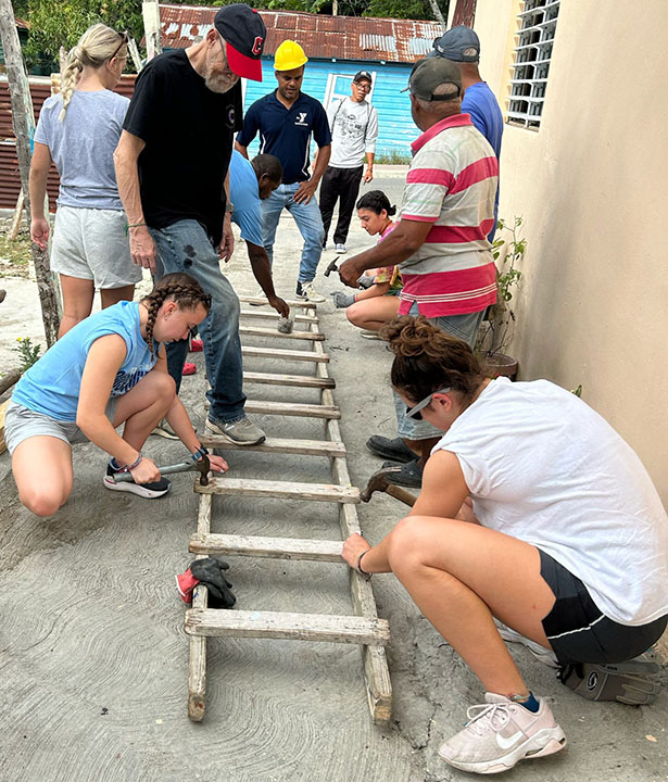 Cooper '26 (Left in blue) hammering a nail