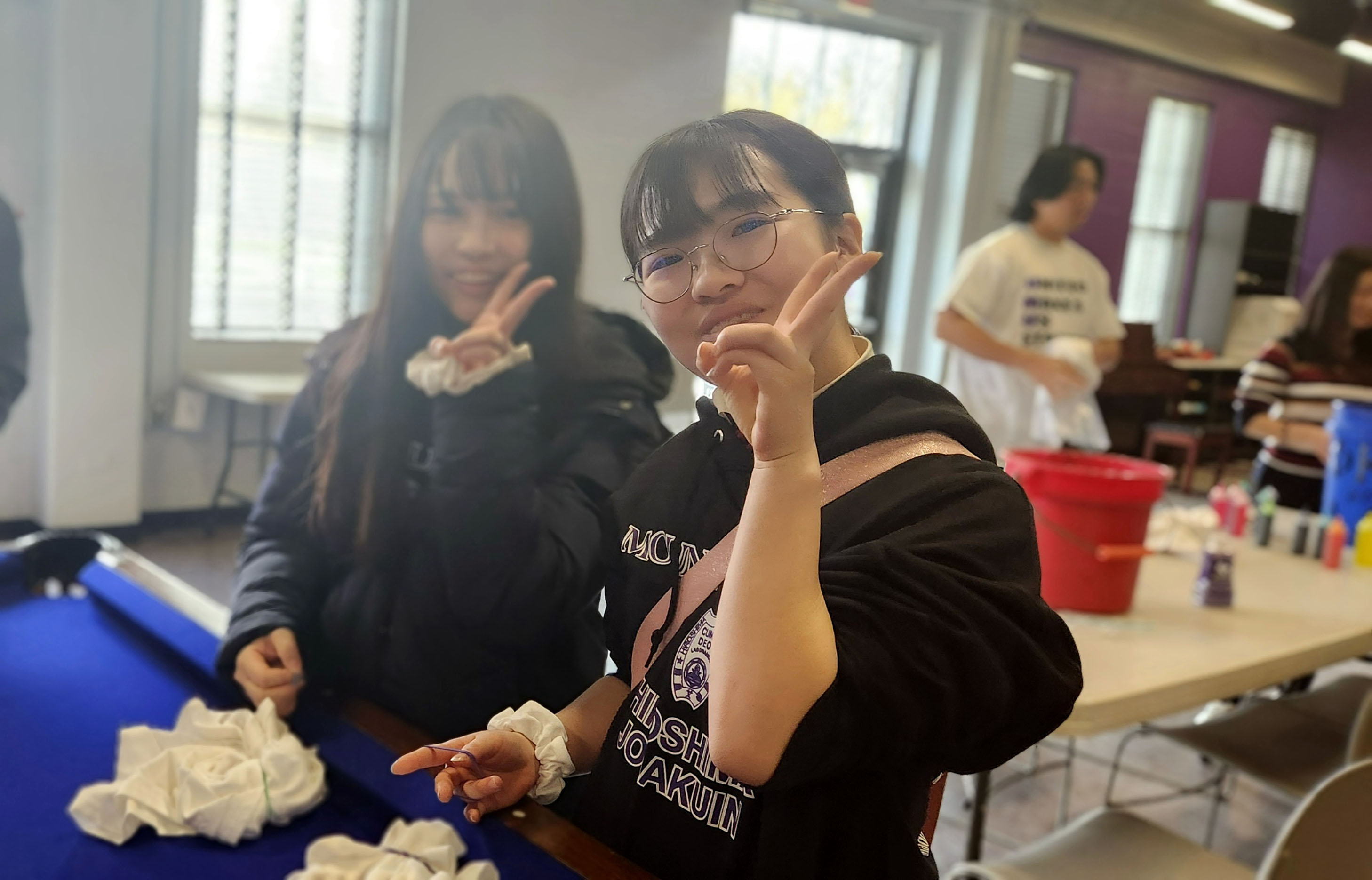 Two visiting students tie dying t-shirts