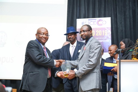 Dr. OK with group at conference shaking hands