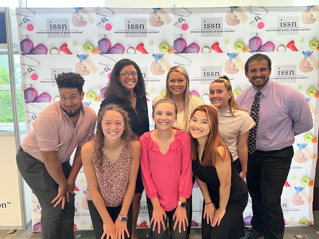 Seven exercise science students pose with smiles at an international research conference