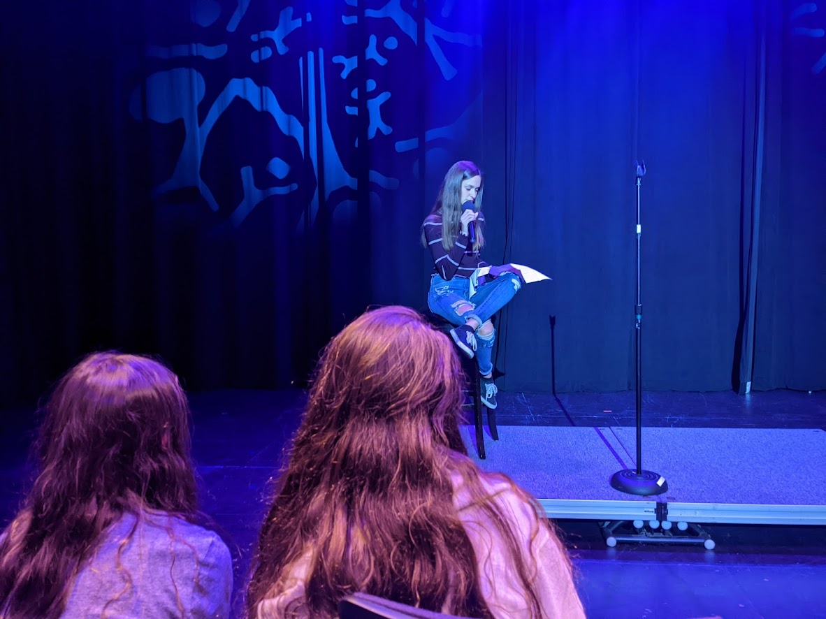 Alyson Kantor '22 delivers a stand up routine on stage in front of a crowd