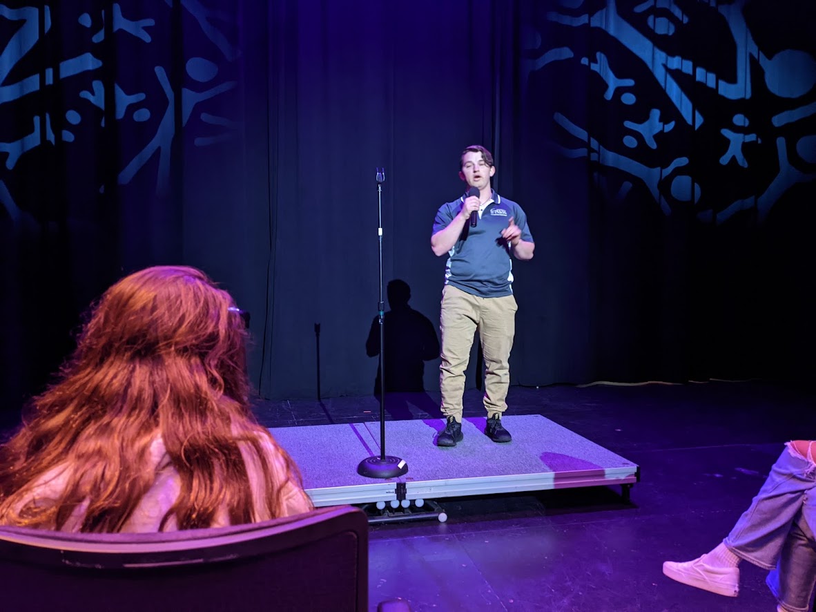 Walter Sterling '22 delivers a stand up routine on stage to a crowd