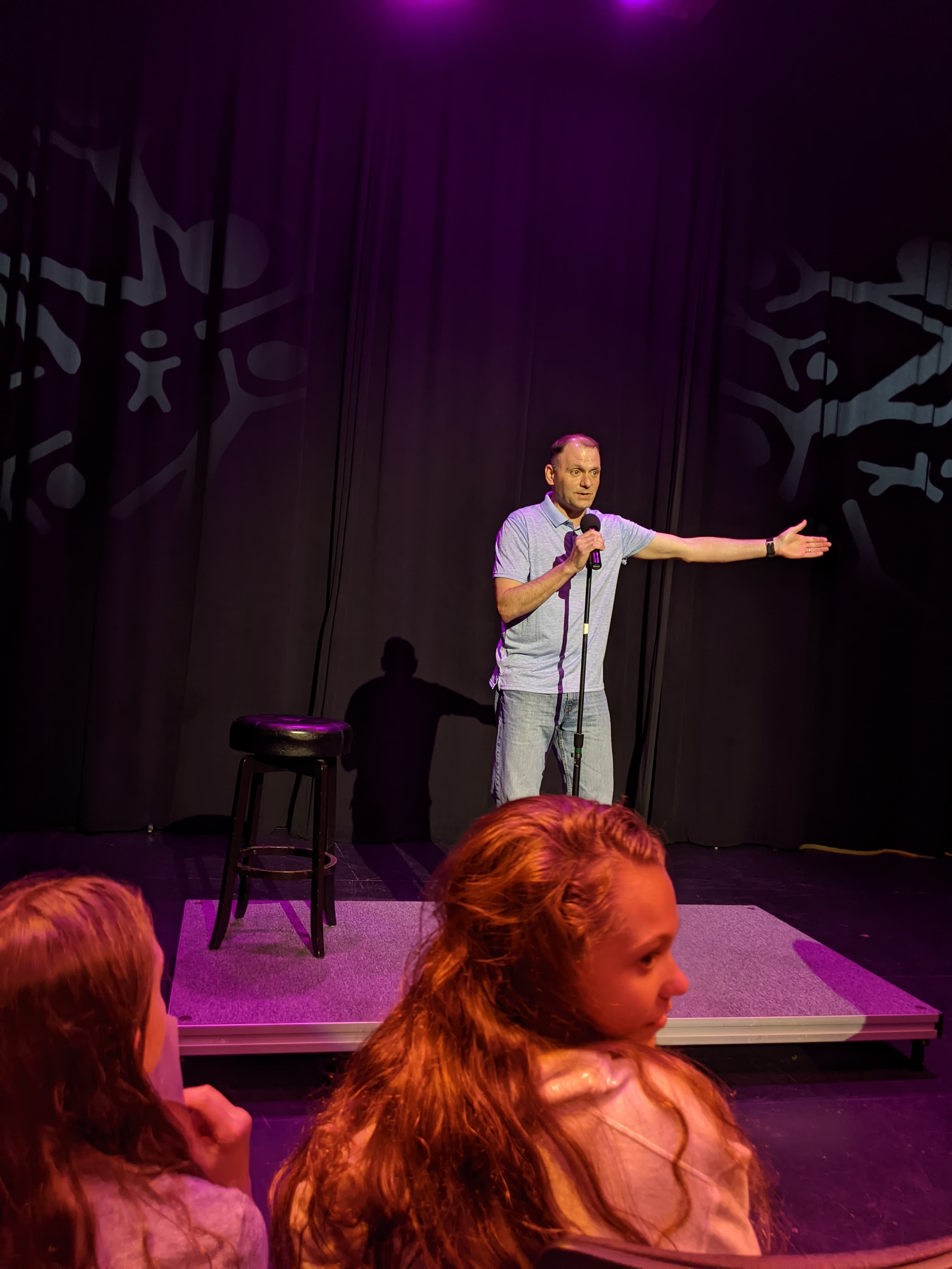 Dr. Kevin Meyer speaks into a microphone on stage in front of a crowd