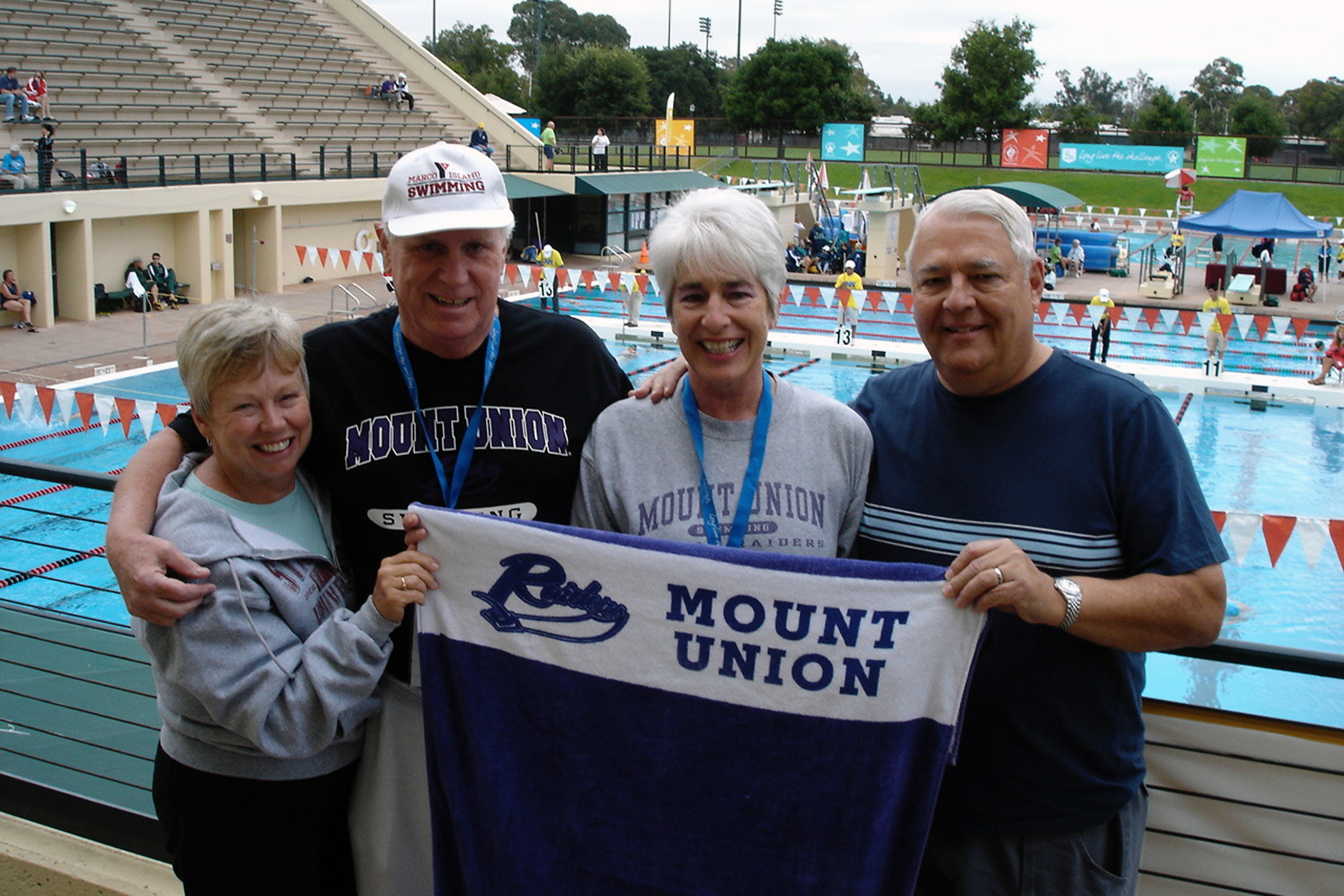 Ed and Sue Merch and Mary and Dee Grapentine in front of a pool