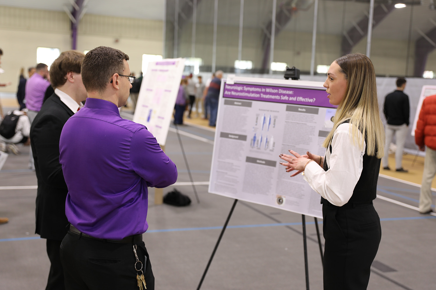 female student talking with man about poster