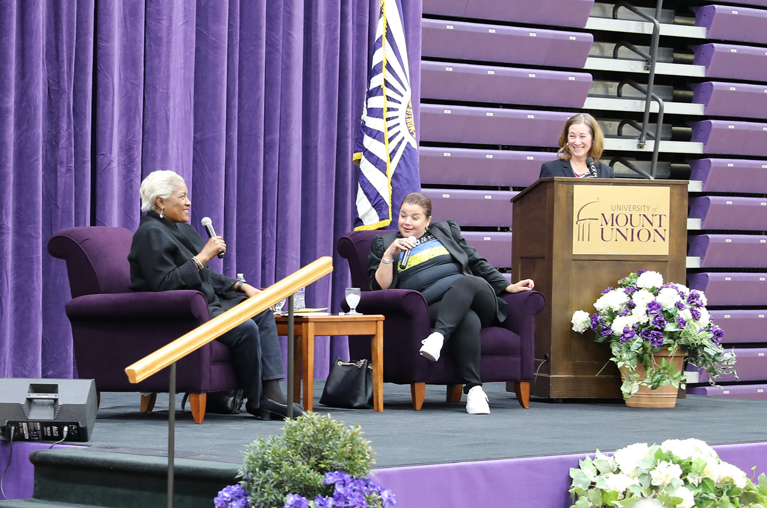 from left to right, donna brazile, ana navarro and dr. jamie capuzza on stage at the 2022 schooler lecture
