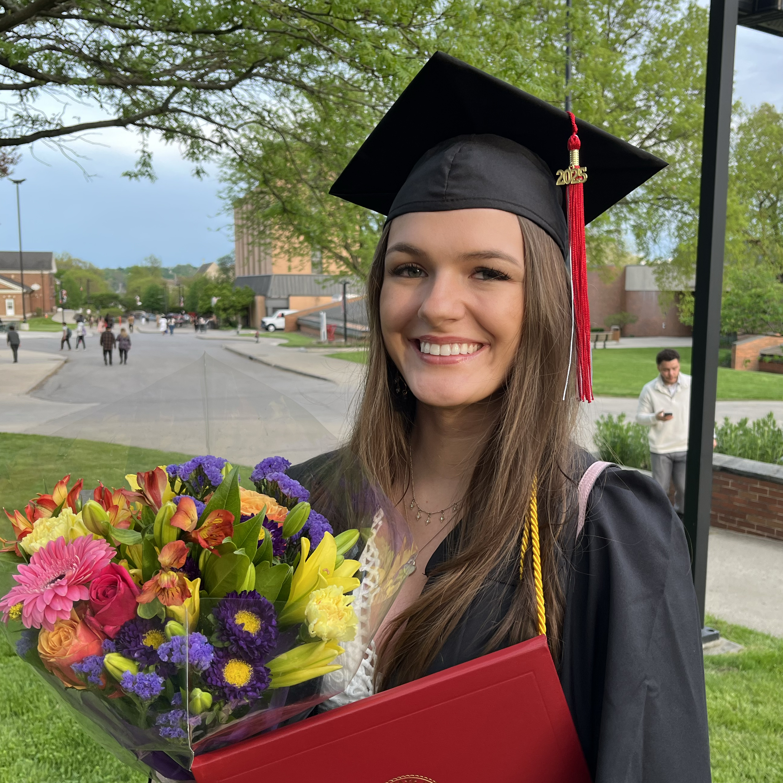 Alyssa Ferguson M'27 posing in undergraduate regalia