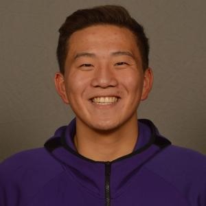 Emmett Martin smiles in front of a gray background